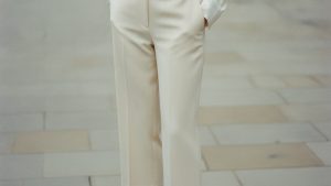 Woman wearing cream wide-leg tailored capri trousers, hemline grazing the ankle bone, sharply pressed with a clean silhouette