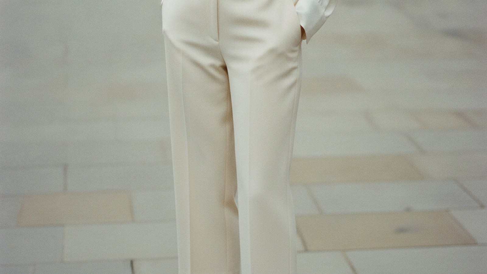Woman wearing cream wide-leg tailored capri trousers, hemline grazing the ankle bone, sharply pressed with a clean silhouette