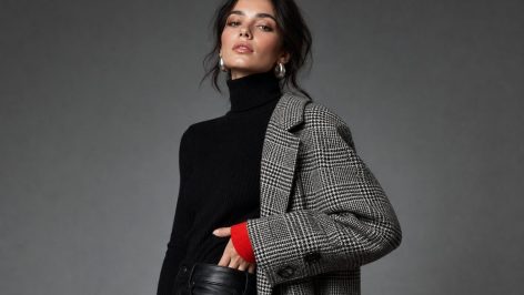UK fashion editor walking through Manchester Northern Quarter in suede trousers, oversized coat and second-hand leather bag during autumn