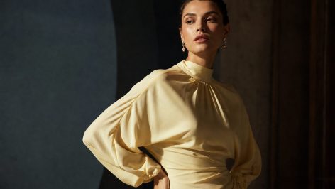 Model in a two-tone taffeta midi dress with ruched loafers and a silk scarf belt, embodying the très chic 7 aesthetic