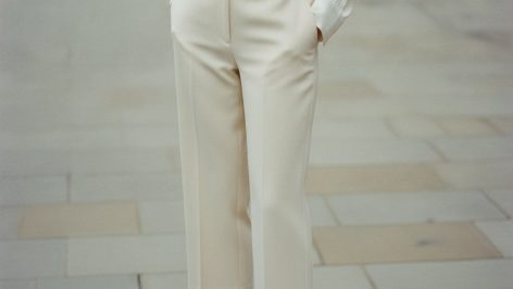 Woman wearing cream wide-leg tailored capri trousers, hemline grazing the ankle bone, sharply pressed with a clean silhouette